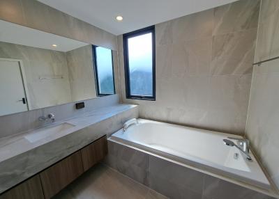 Spacious bathroom with modern fittings, a bathtub, and a scenic view