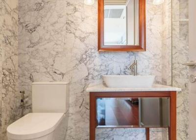 Modern bathroom with marble finishing and wooden vanity