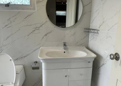 Modern bathroom with marble walls and white fixtures