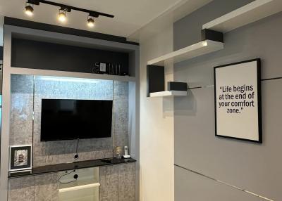 Modern living room with wall-mounted TV and inspirational quote