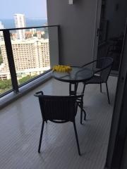 Modern balcony with glass table and chairs overlooking a cityscape