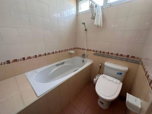 Spacious bathroom with bathtub, toilet, and bidet