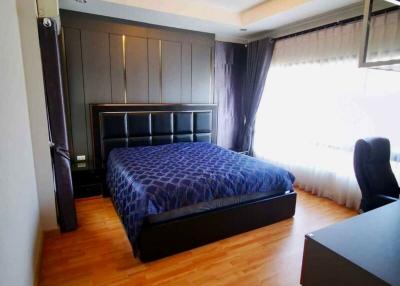 Spacious bedroom with wooden floor and large bed