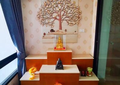 Elegant meditation space with Buddha statue and decorative tree artwork