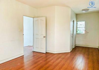 Spacious bedroom with hardwood floors and natural light