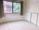 Bright and airy single bedroom with a large window and tiled flooring