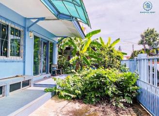 Cozy home exterior with a vibrant garden and veranda