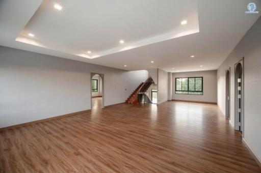 Spacious living room with wooden flooring and ample natural light