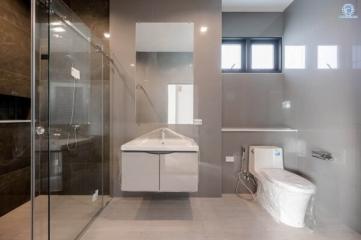 Modern bathroom with walk-in shower, bathtub, and toilet