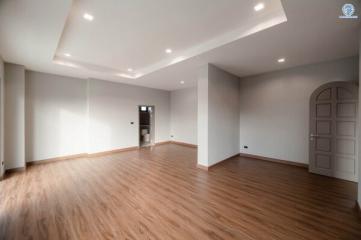 Spacious unfurnished living room with hardwood floors and recessed lighting