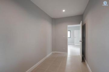 Bright and spacious corridor with tiled flooring and neutral color walls