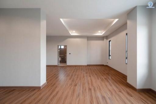 Spacious and well-lit living room with hardwood floors and modern lighting