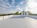 Spacious rooftop with a skyline view and small structure
