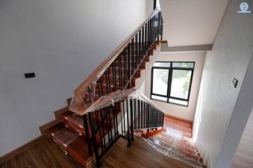 Elegant wooden staircase with iron railings inside a newly constructed home