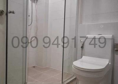 Modern white tiled bathroom with shower enclosure and toilet