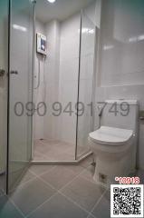 Modern white tiled bathroom with shower enclosure and toilet