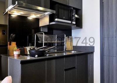 Modern compact kitchen with black cabinets and stainless steel appliances