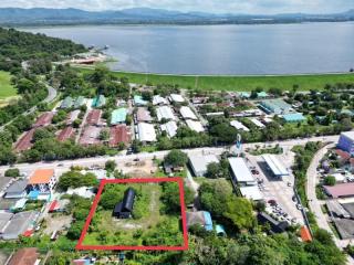 Aerial view of a residential area near a water body with a property highlighted in red