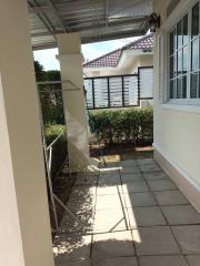 Paved outdoor side passage of a residential home with partial view of the windows and roof