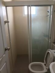 Compact bathroom with glass shower enclosure and white toilet