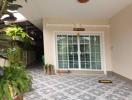 Spacious tiled patio with large windows and potted plants