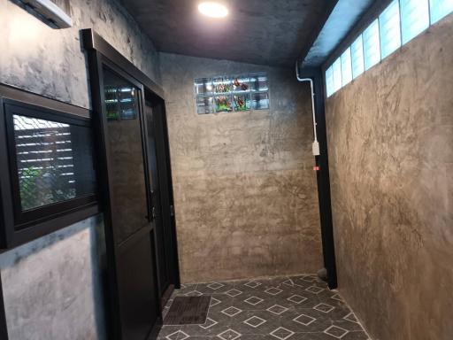 Dimly lit hallway with patterned floor and concrete walls