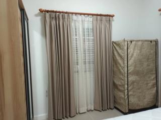 Cozy bedroom with neutral-toned curtains and natural light