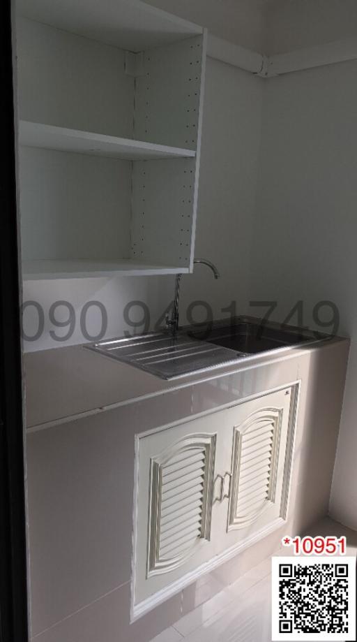 Compact kitchen with white cabinetry and stainless-steel sink