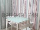 Modern dining space with table and chairs and striped curtains