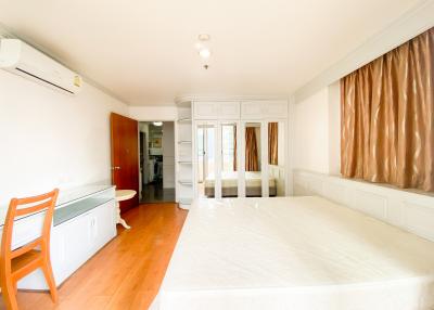 Bright and spacious bedroom with large bed and modern air conditioning unit