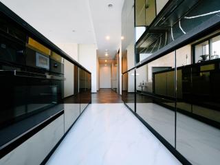 Spacious modern kitchen with high-gloss cabinets and white countertops