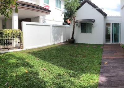Spacious garden with green lawn and modern two-storey house exterior