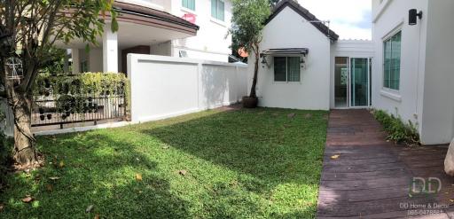 Spacious garden with green lawn and modern two-storey house exterior