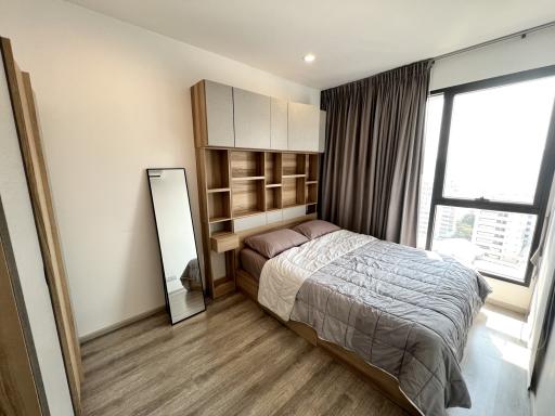 Modern bedroom with large window and built-in shelves