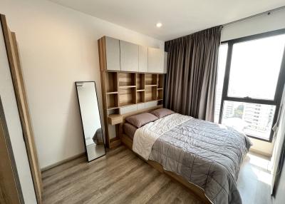 Modern bedroom with large window and built-in shelving