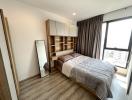 Modern bedroom with large window and built-in shelving