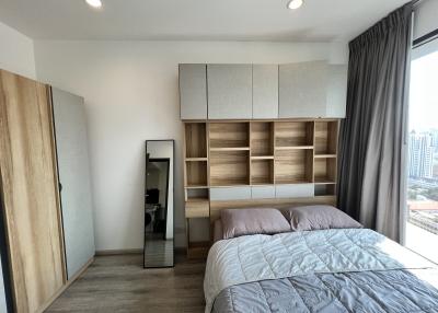 Modern bedroom with large bed and built-in wooden shelving