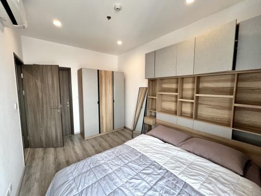 Modern bedroom with large bed and built-in wooden wardrobes