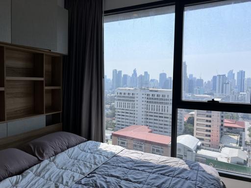 Modern bedroom with large window overlooking the city