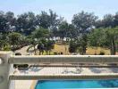 Balcony view overlooking a pool and garden