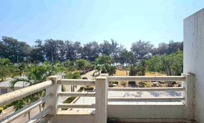 View from a balcony overlooking green trees in a sunny day