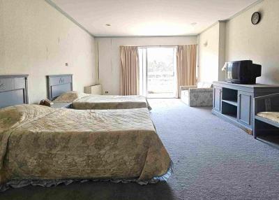 Spacious double bedroom with two beds and ample natural light