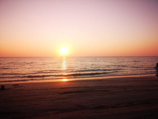 Serene beach sunset with calm waves and clear sky