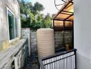 Compact outdoor area with a large water tank and fencing