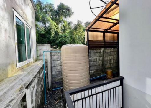 Compact outdoor area with a large water tank and fencing