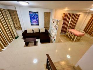 Spacious modern living room with glossy tiled flooring, comfortable furniture and bright lighting