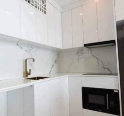 Modern white kitchen with marble backsplash and built-in appliances