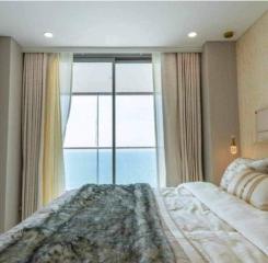 Modern bedroom with a large window providing an ocean view