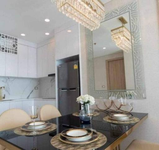 Modern kitchen with elegant dining table setup and chandeliers