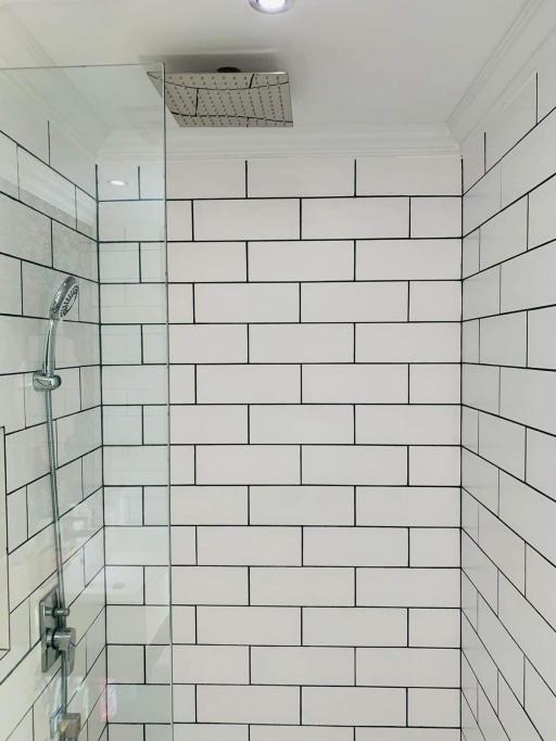 Modern white tiled bathroom with glass shower enclosure